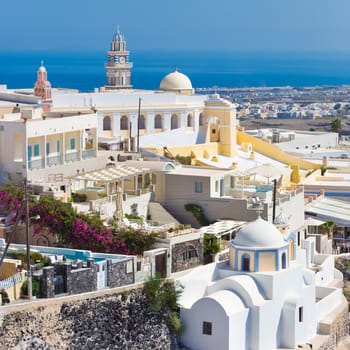 Cityscape of Fira, dramatically located on the edge of the caldera cliff on the island of Thira known as Santorini, Greece. Panorama shot.