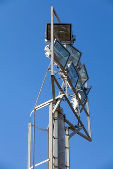 Stadium lights in daytime against blue sky