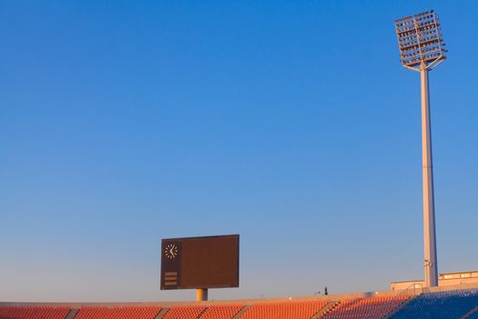 Stadium lights and scoreboard at blue sky