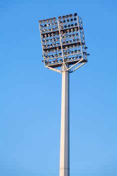 Stadium lights in daytime against blue sky