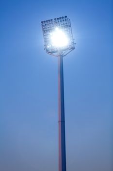 Stadium lights in daytime against blue sky