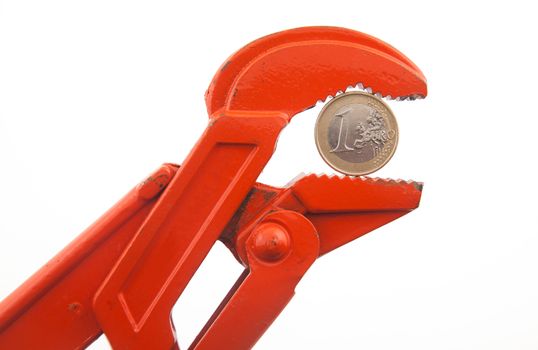 Financial crisis, euro in press, economy concept. Orange wrench pressing a euro coin