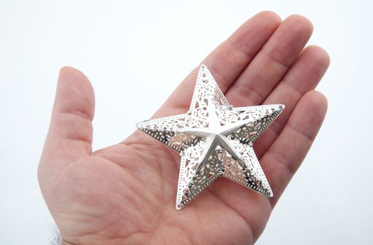 Five pointed silver star into the human palm