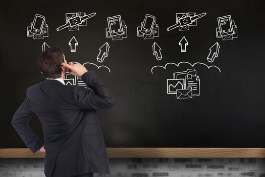 Thinking businessman scratching head against blackboard on wall with business technology doodle