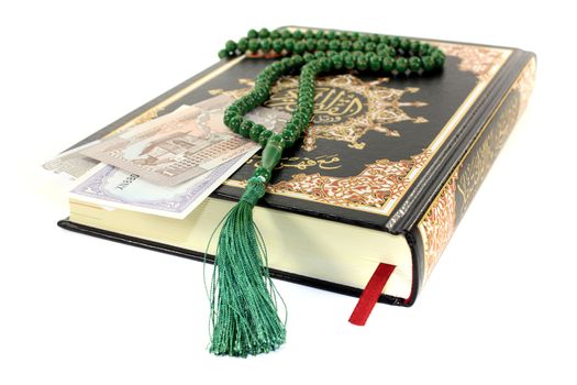 slammed Quran with Pakistani currency before light background