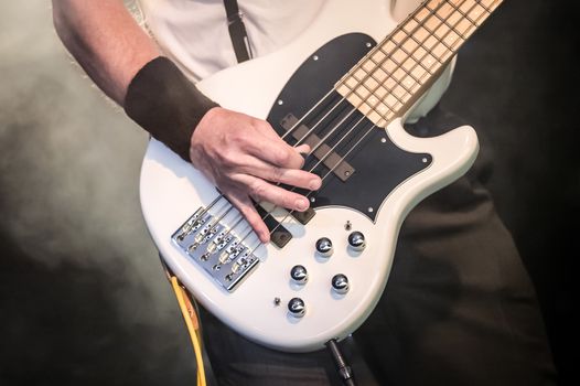 hand of a musician playing a five string bass guitar