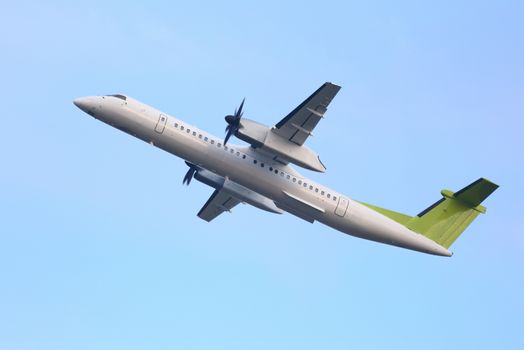 Airplane flying away to the blue sky