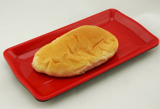 Thai custard bread on red plate, is sweet ,delicious and appitizing.                              