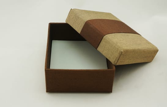 Opened gift box packaging, the exterior is made from fabric with gold and brown color.                               