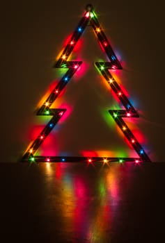 Christmas lights on a Christmas tree and its reflection