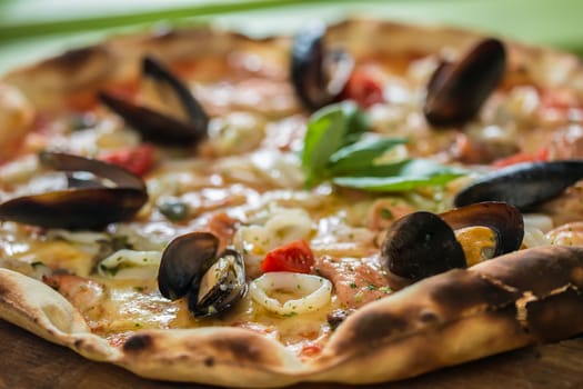 Traditional italian seafood pizza with prawns and mussels. selective focus