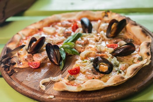 Traditional italian seafood pizza with prawns and mussels. selective focus
