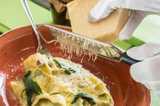 Ravioli pasta from green dough with mushroom stuffing, oil, parsley, vegetarian dish. selective focus