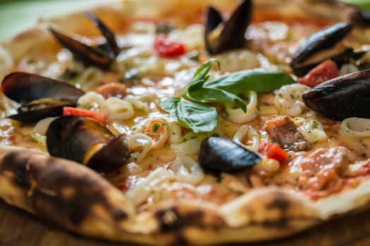 Traditional italian seafood pizza with prawns and mussels. selective focus