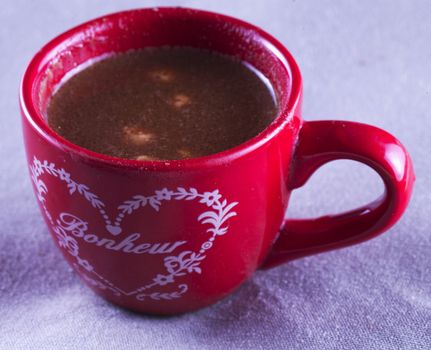 Chocolate in red cup over gray tissue