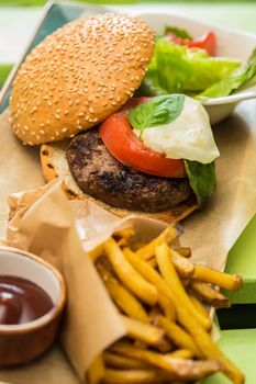 Delicious burger with beef, tomato, lettuce and fries. selective focus