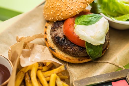 Delicious burger with beef, tomato, lettuce and fries. selective focus