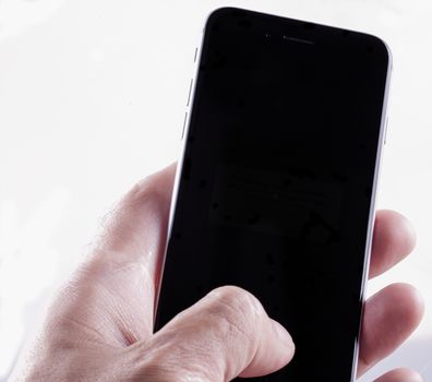 Male hand over smartphone, isolated over white