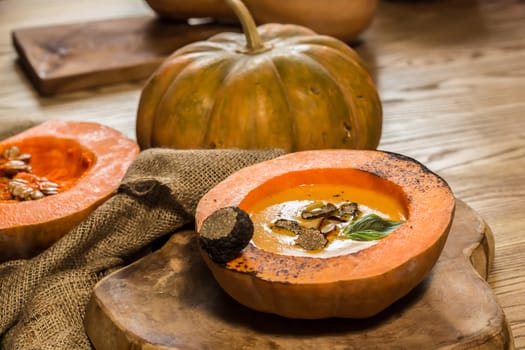 Cream of pumpkin soup with pumpkin seeds and and garlic croutons  in hollowed-out pumpkin. Shallow dof.