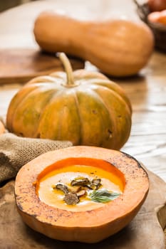 Cream of pumpkin soup with pumpkin seeds and and garlic croutons  in hollowed-out pumpkin. Shallow dof.