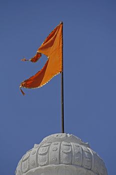 Orange Hindu temple flag in the breeze at Shrinath Mhaskoba Temple, Kodit, Sasvad, Maharashtra, India.