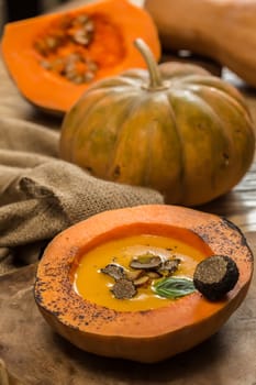 Cream of pumpkin soup with pumpkin seeds and and garlic croutons  in hollowed-out pumpkin. Shallow dof.