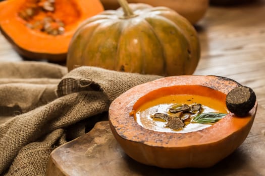 Cream of pumpkin soup with pumpkin seeds and and garlic croutons  in hollowed-out pumpkin. Shallow dof.