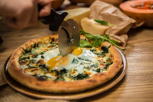 Margarita pizza with arugula and egg for breakfast, selective focus