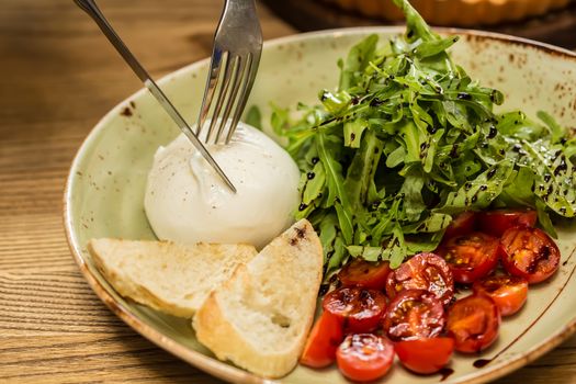 Burrata mozzarella cheese, tomato and bread, selective focus