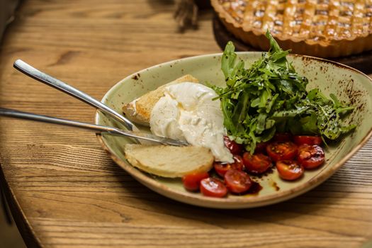 Burrata mozzarella cheese, tomato and bread, selective focus