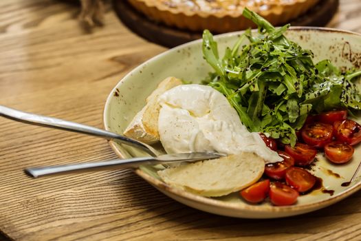 Burrata mozzarella cheese, tomato and bread, selective focus