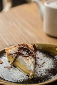 Cheesecake with Chocolate, baked to perfection. On plate with terracotta background. 