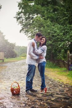 Young couple in Ukrainian style clothes standing under rain