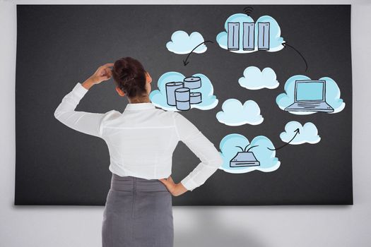 Businesswoman scratching her head against black chalkboard with business technology doodle