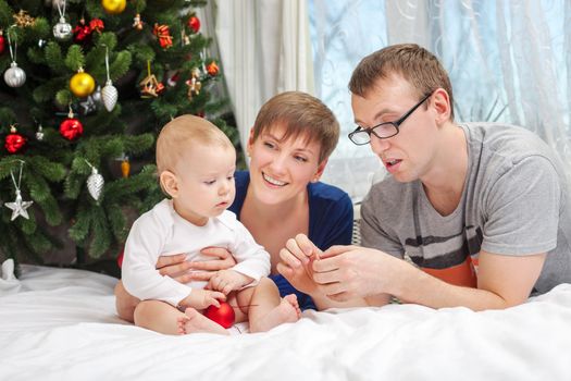 Young family with baby boy looking at Christmas decorations