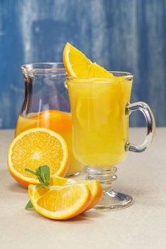 Orange juice and fresh oranges over rustic background