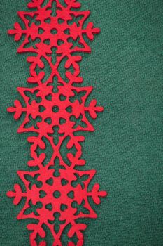 Christmas background with snowflakes. Christmas card with red snowflakes against green background.