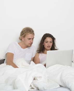 Married couple with a laptop in bed