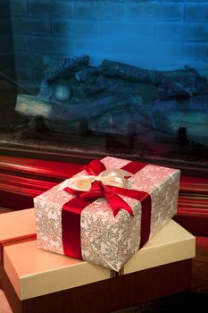 Christmas gift boxes with red ribbon in the interior with a fireplace