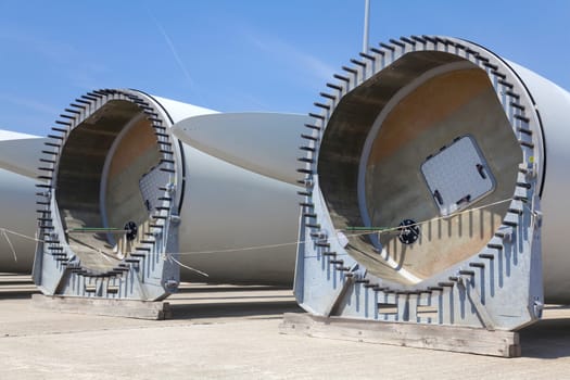 Giant wind turbine awaiting assembly at wind farm.