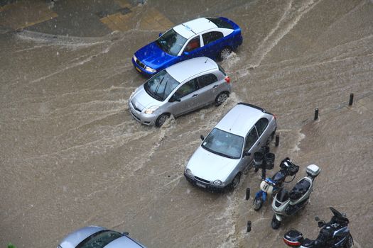 Thessaloniki, Greece - June 15, 2011: People try to cross a flooded road in the center of city. The summer months are a common phenomenon reason for the poor maintenance of drains