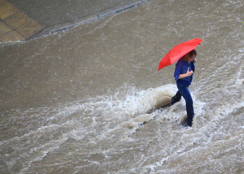 Thessaloniki, Greece - June 15, 2011: People try to cross a flooded road in the center of city. The summer months are a common phenomenon reason for the poor maintenance of drains