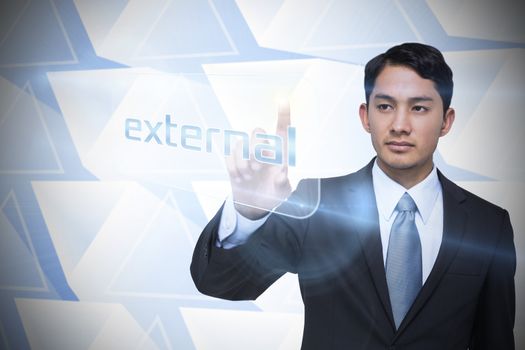 Businessman pointing to word external against abstract glowing triangles