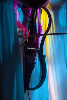Playing cello, between colorful night lights