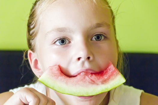 Photo of the cute girl eating watermelon