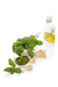 Basil pesto, fresh basil leaves, garlic, pamrmigiano cheese, olive oil and pine seeds isolated on white background. 