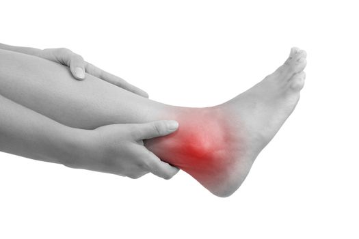 Sprained ankle, muscle injuries and muscle strain. Female hand holding leg with highlighted pain area isolated on white background.