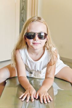 Photo of cute girl playing with sunglasses