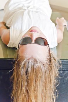 Photo of cute girl playing with sunglasses