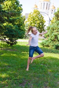 Cute girl with blond hair jumping on one leg